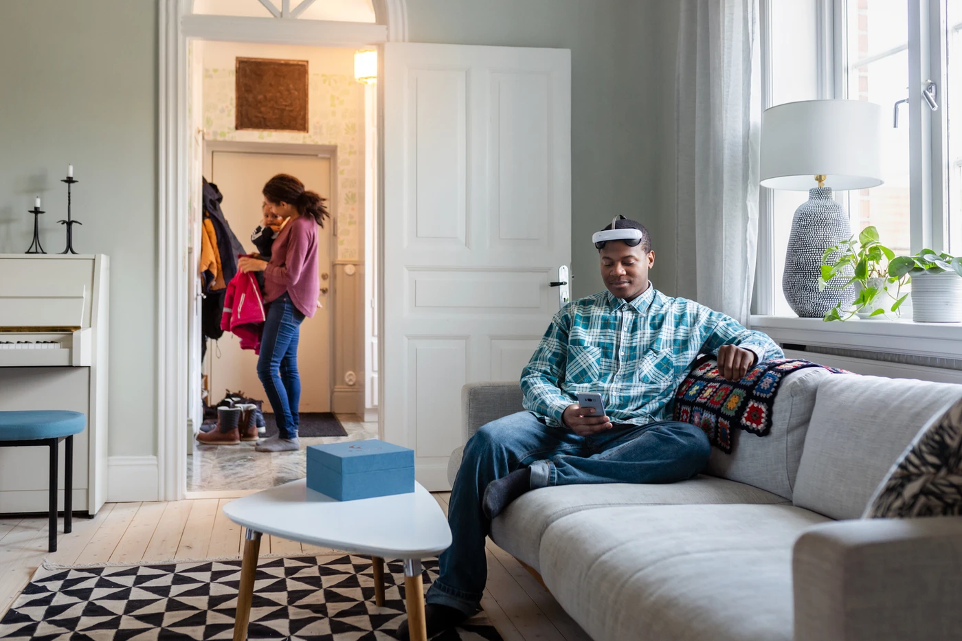 man using the Flow tDCS headset on sofa